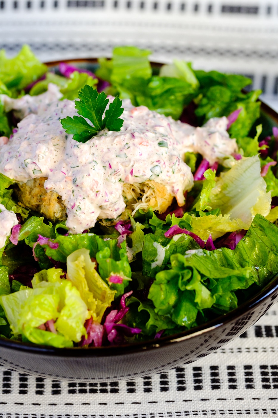 Lectin-free crab cakes in a bowl of salad with homemade remoulade