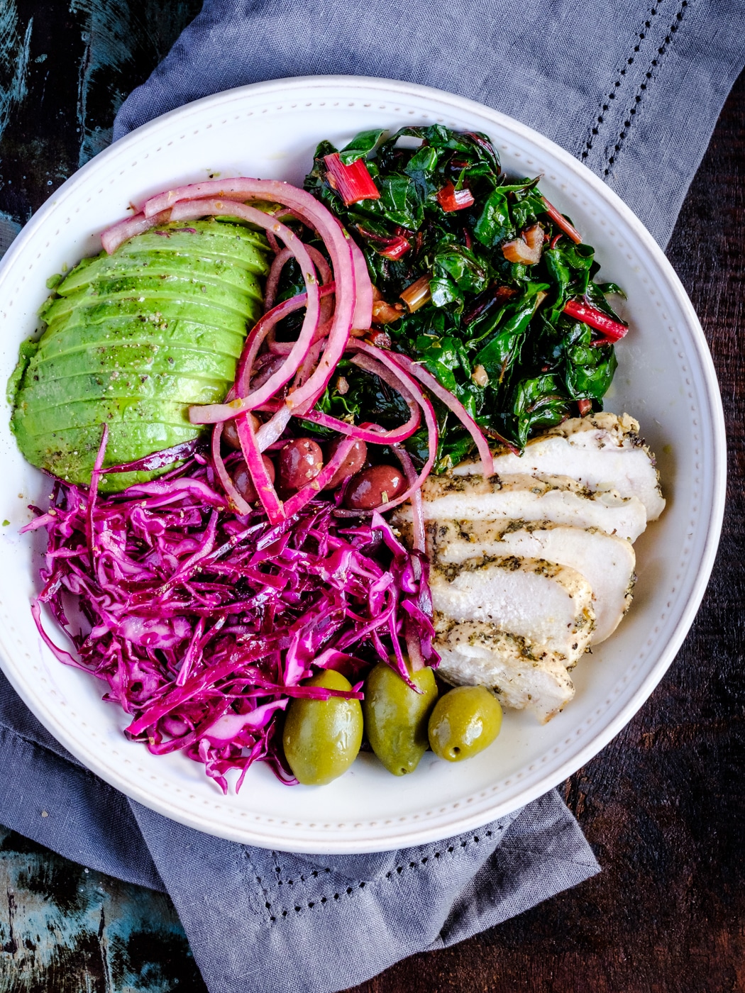 Buddha bowl with chicken, Swiss chard, cabbage salad, and avocado