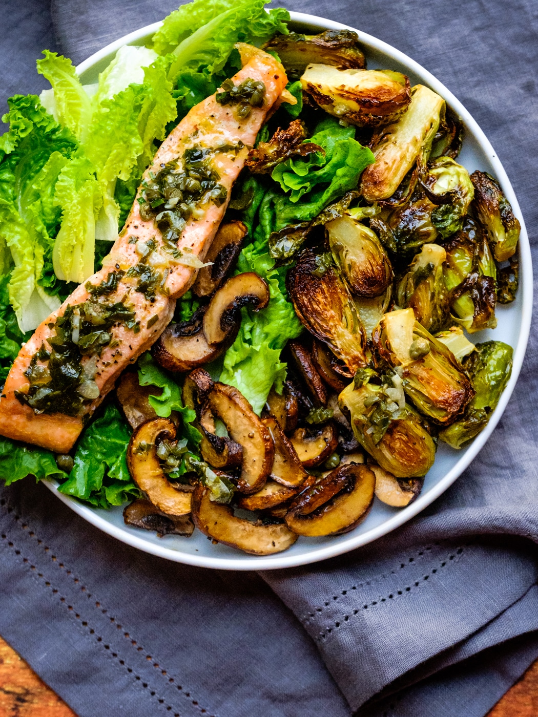 Salmon with capers-lemon sauce with roasted Brussel sprouts on a bed of lettuce