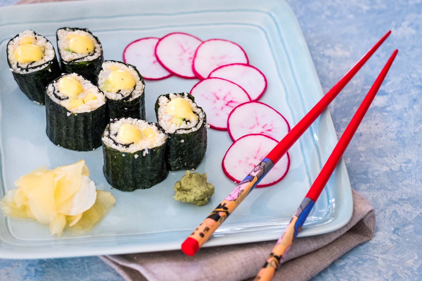 Lectin-free sushi rolls with cauliflower rice served on a plate and ready to eat with chop sticks