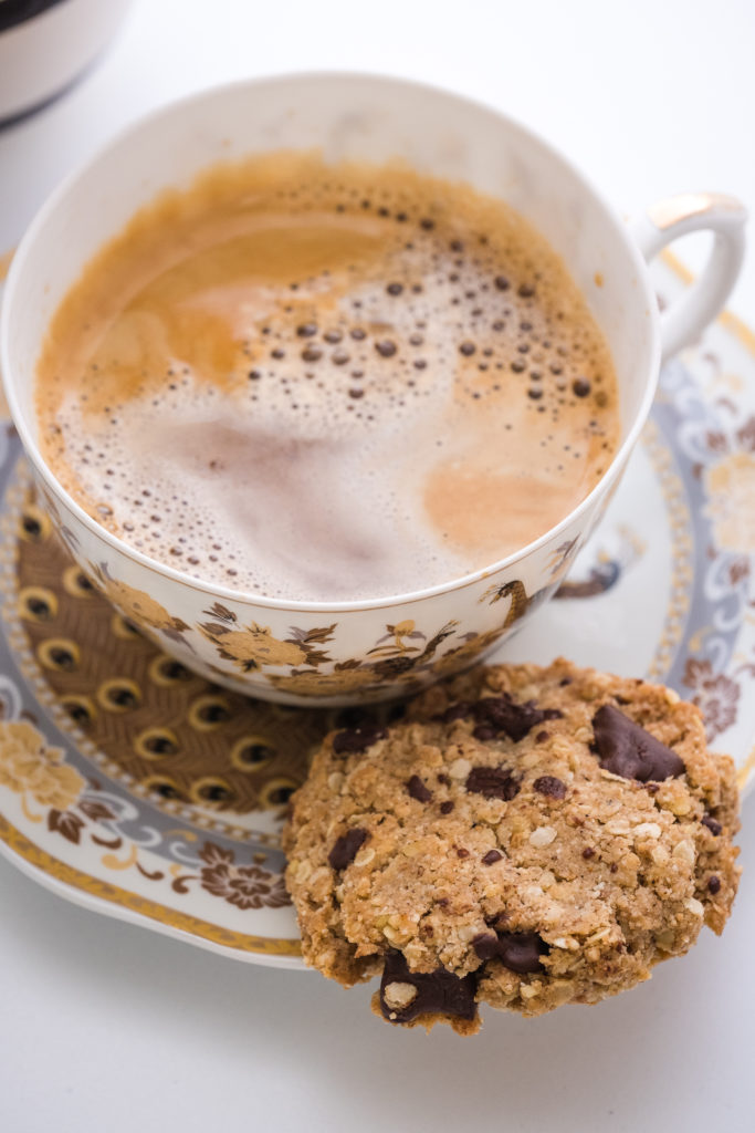 A cup of coffee and a millet flakes chocolate chip cookie