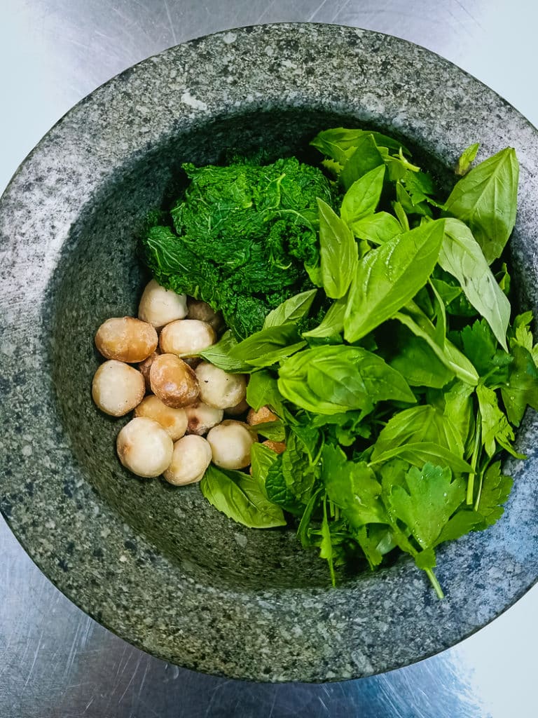 All the ingredients for the pesto in a mortar