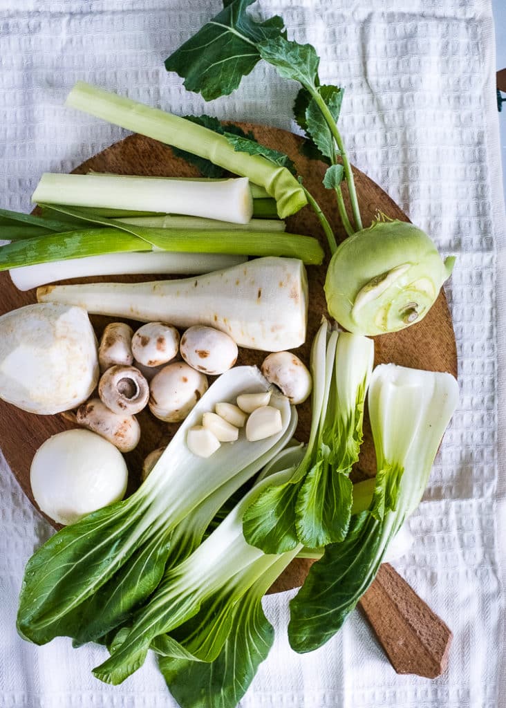 a variety of vegetables on a cutting board, cleaned and ready to make a lentil soup