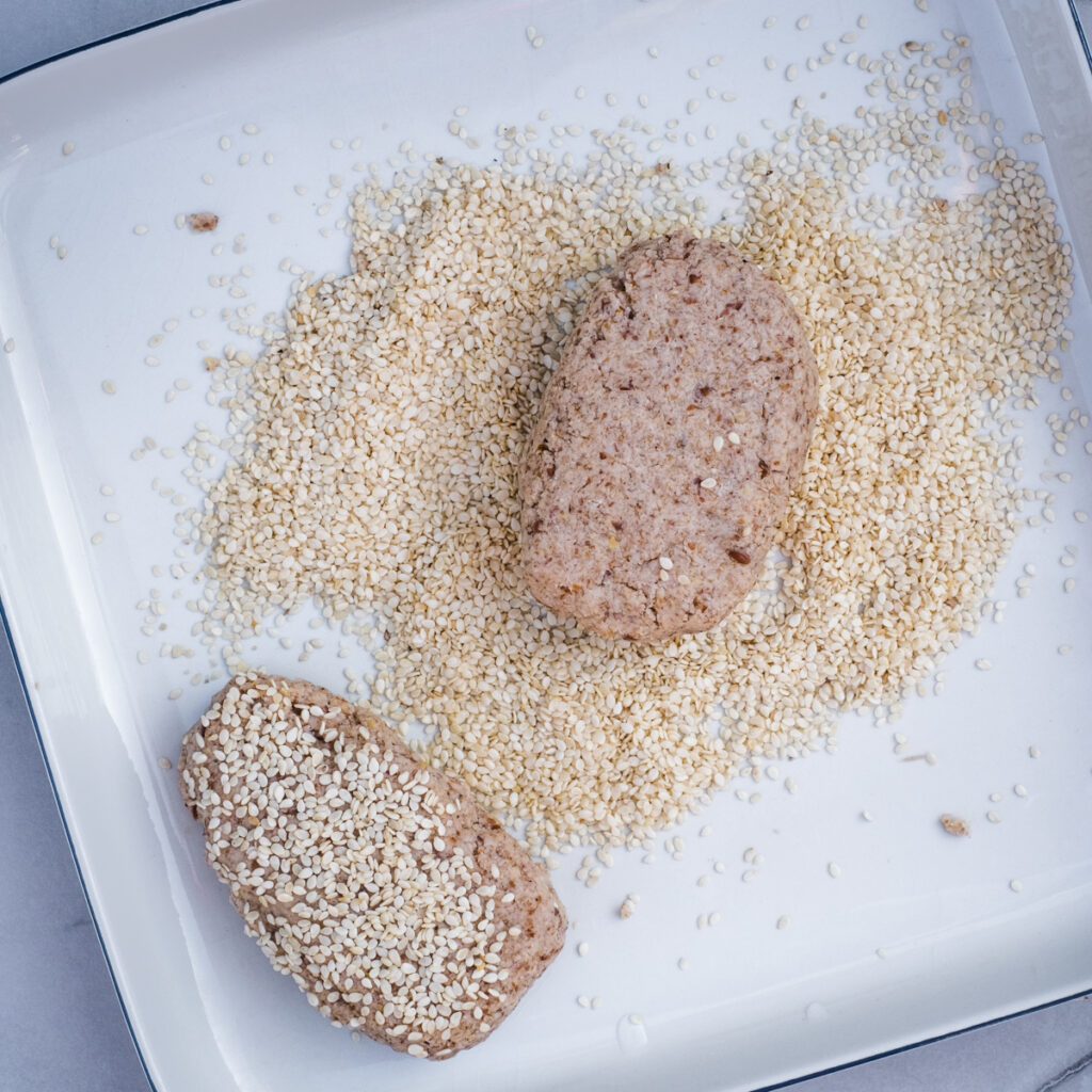 The sorghum bread buns on a plate with sesame seeds