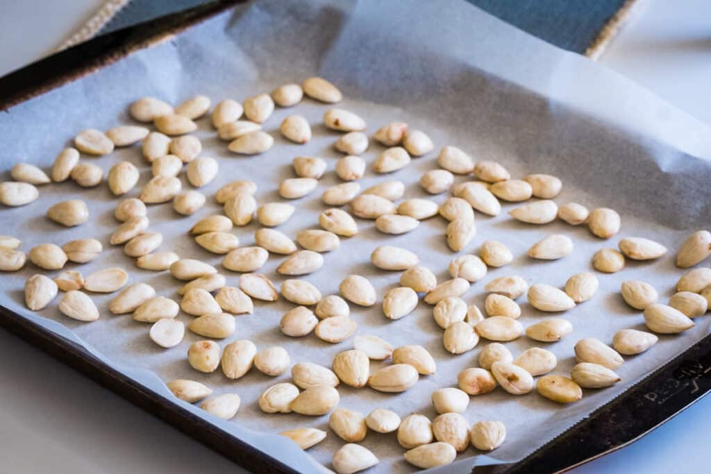 Almonds on a cutting board. The peels have been removed to reduce the lectins.