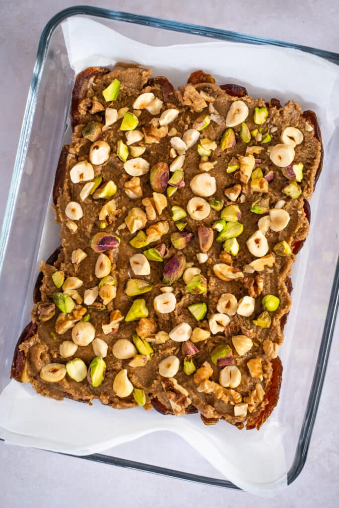 chopped nuts on a layer of walnut butter and dates