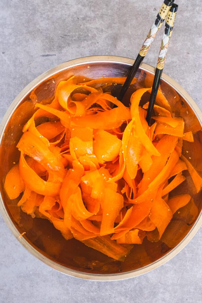 In a large bowl, combining the carrot ribbons with the dressing and sesame salt.