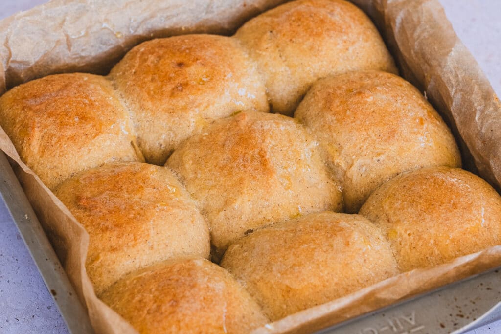 Soft gluten-free sourdough rolls in a baking dish.