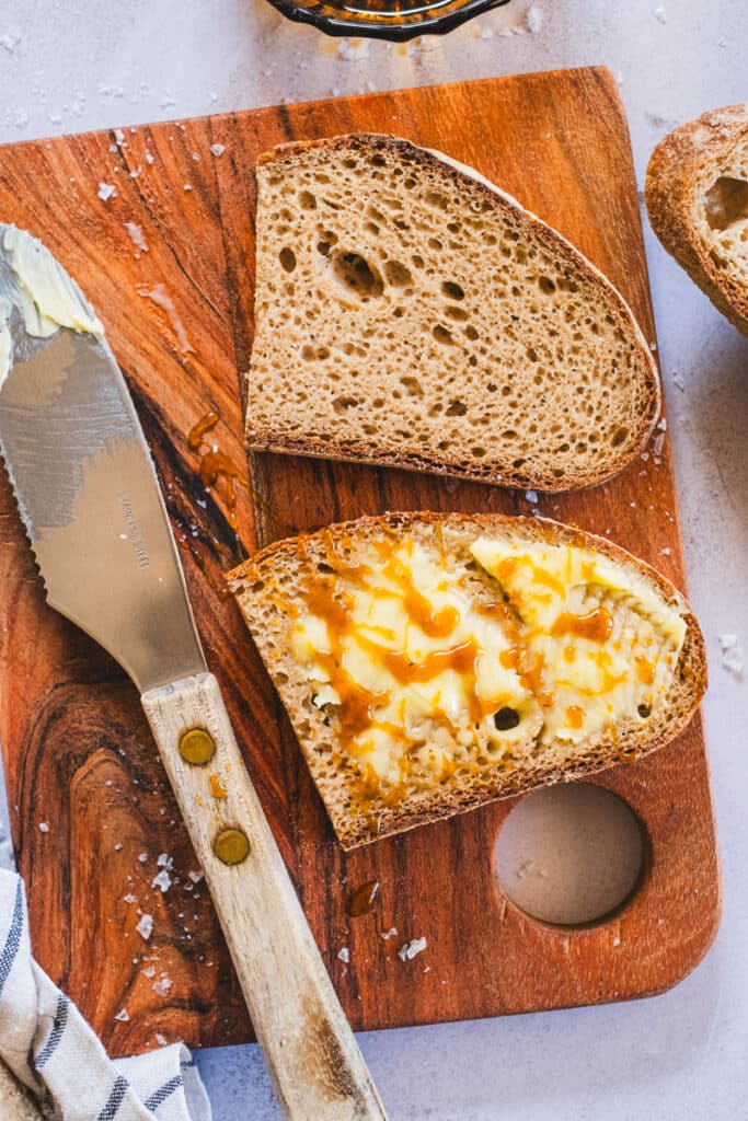 two slices or teff sourdough bread, one plain and one with butter and honey