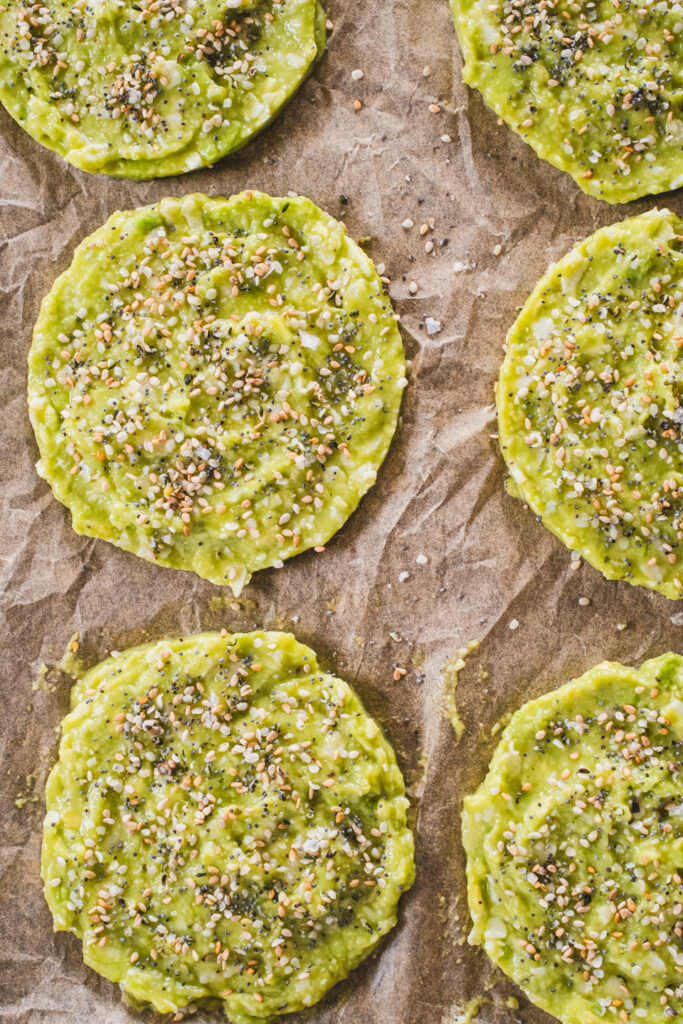 The avocado bread mixture shaped into patties on a baking sheet, ready to be baked in the oven.