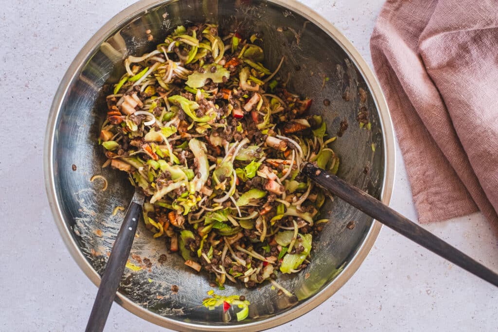 The salad has been tossed in the mixing bowl.