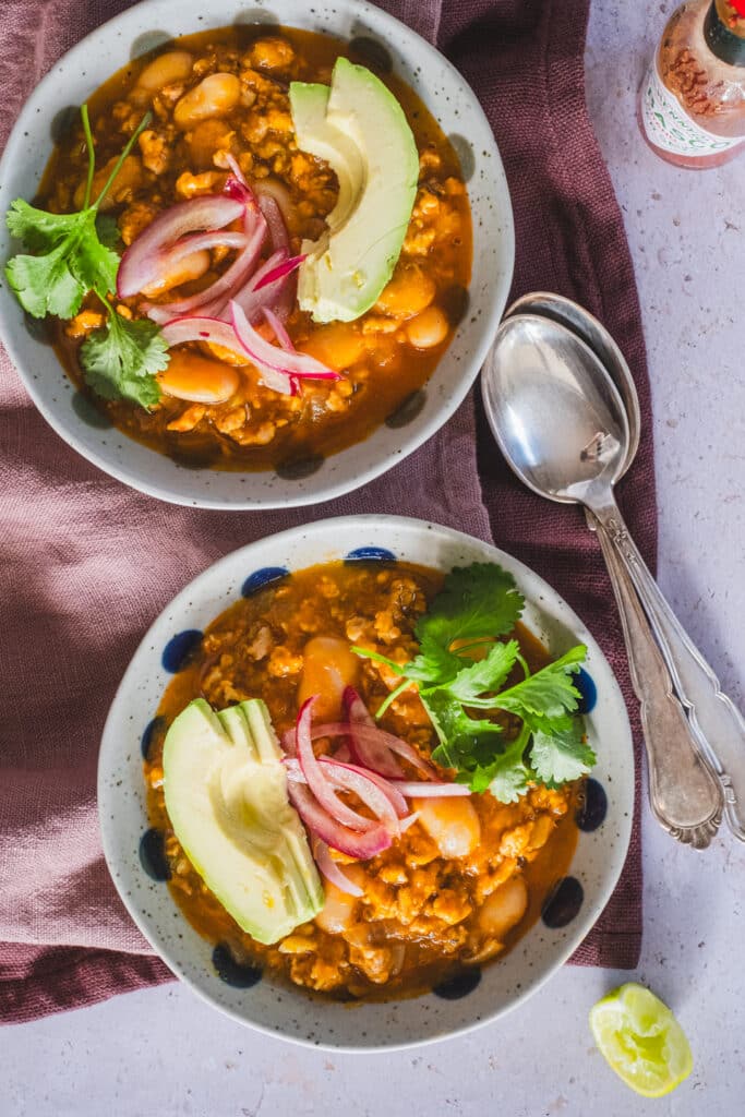 Two bowls of turkey pumpkin chili with butter beans.
