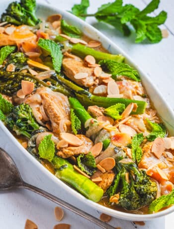 moroccan chicken with broccolini and almonds on a serving platter