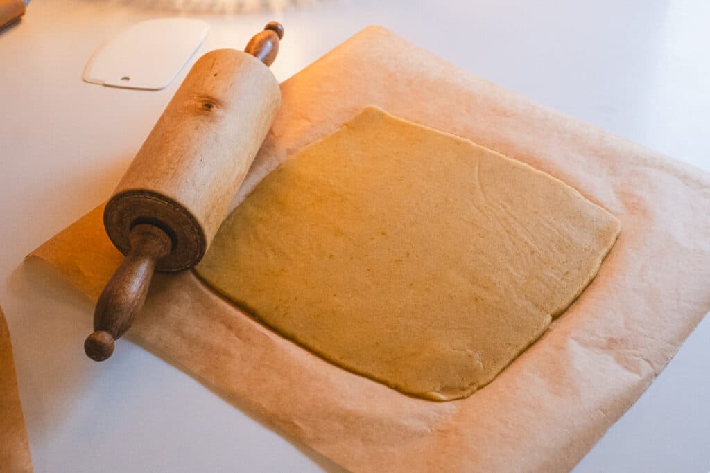 rolled out dough on parchment paper and rolling pin