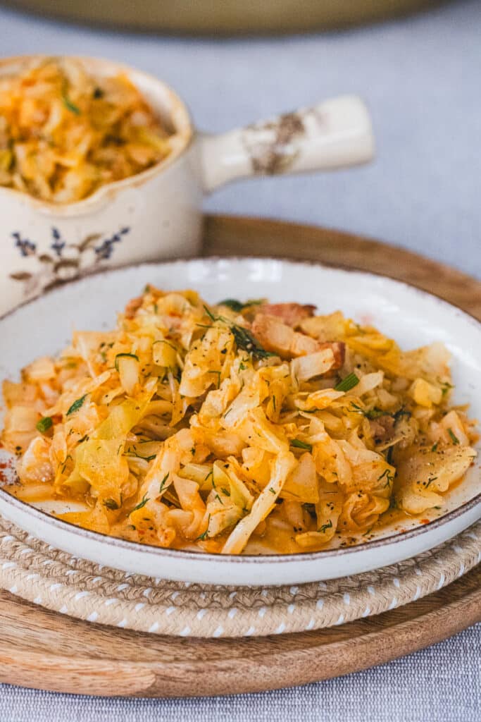 Slow-Cooked Cabbage with Smoked Bacon and Dill served on a plate.