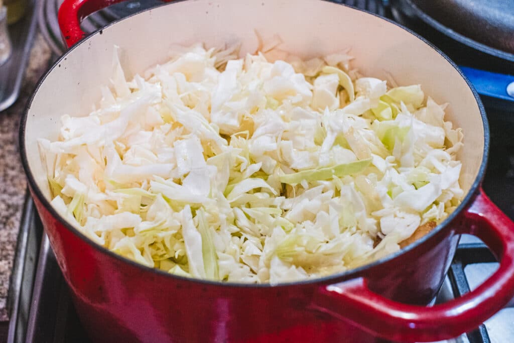 The cabbage has been added to the cooking pot.