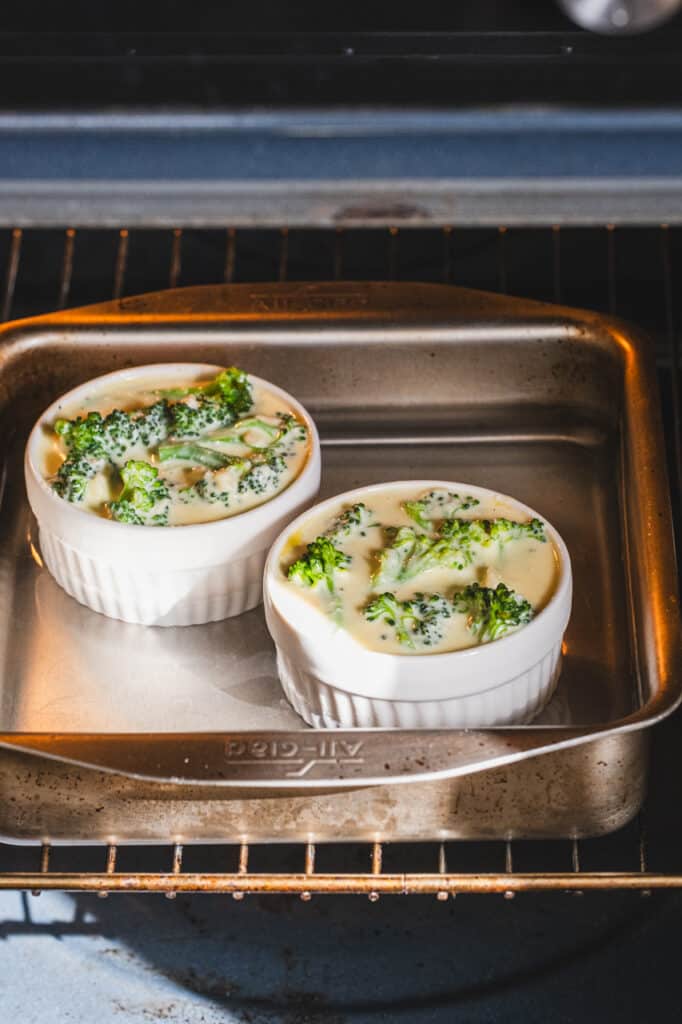The baking dish is filled with hot water, and the ramekins are placed inside it.