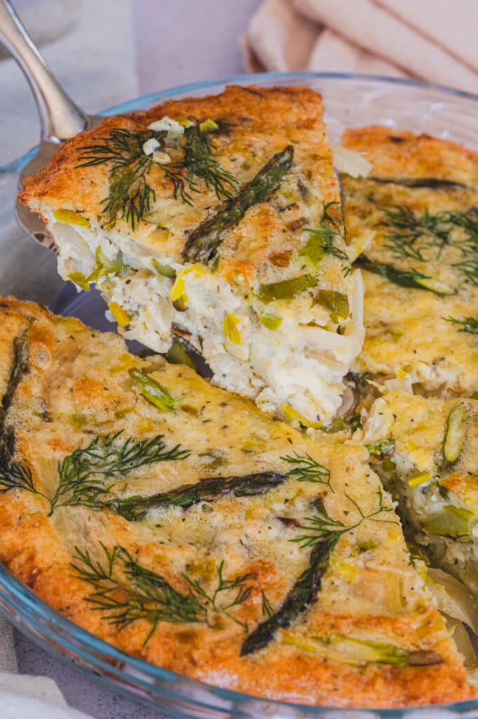 A single serving of crustless vegetable quiche, showing visible pieces of leeks, fennel, and asparagus.