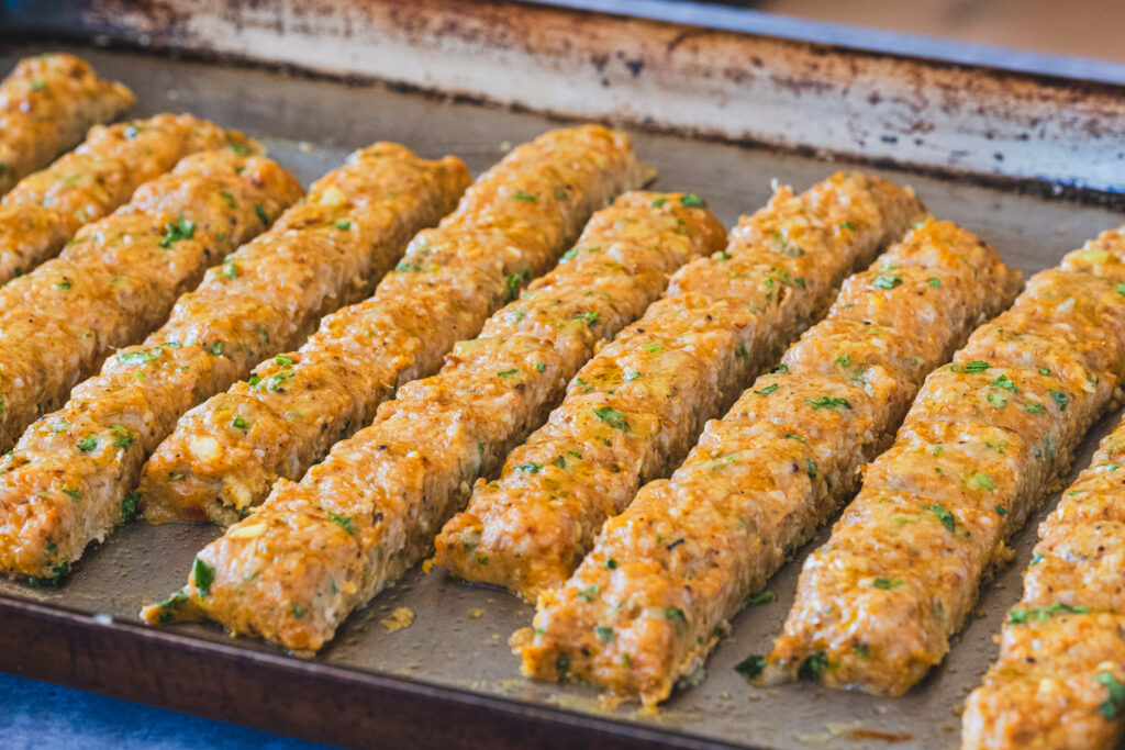 Golden-brown chicken kebabs resting on a sheet pan, fresh from the oven.