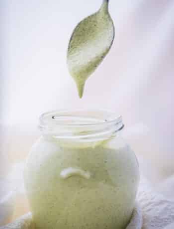 Dairy free ranch dressing in a jar, running from a spoon