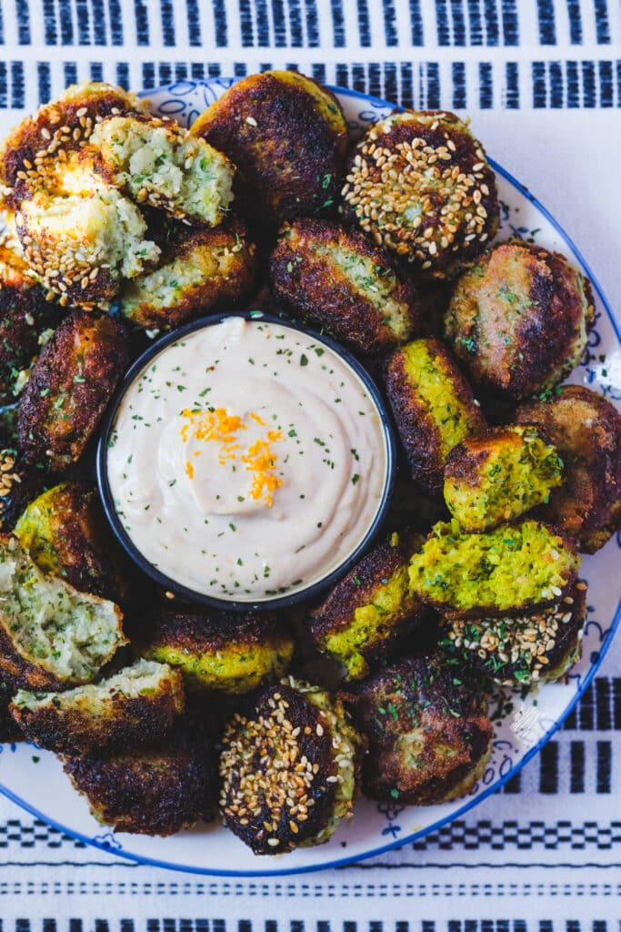chickpea free cauliflower falafel on a plate, with tahini sauce
