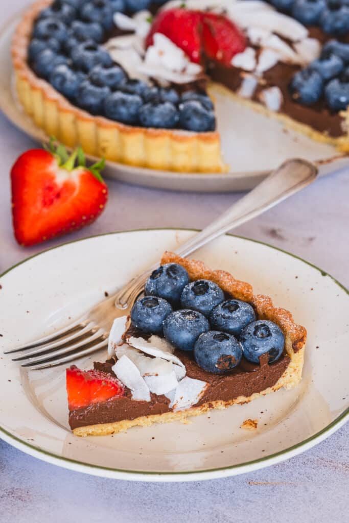 a slice of chocolate and blueberry gluten free tart