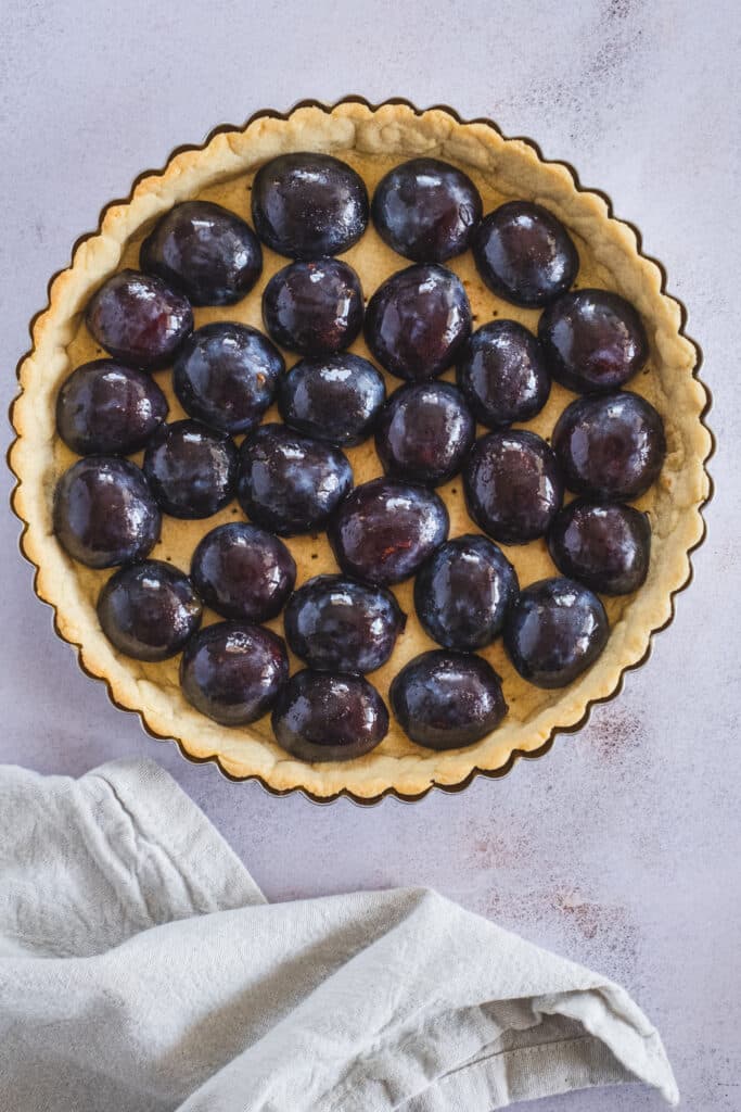 Gluten free tart crust filled with halved plums