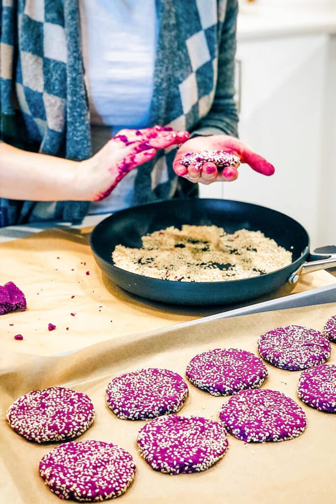 Coating the soft purple sweet potato cookies with sesame seeds